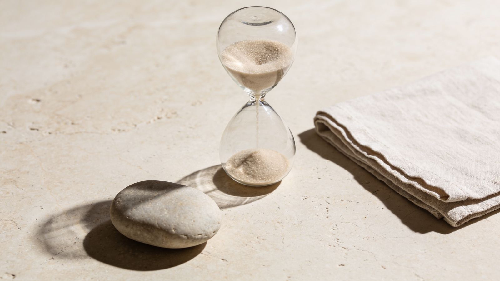 An hourglass on stone, representing how long the results of aesthetic treatments last