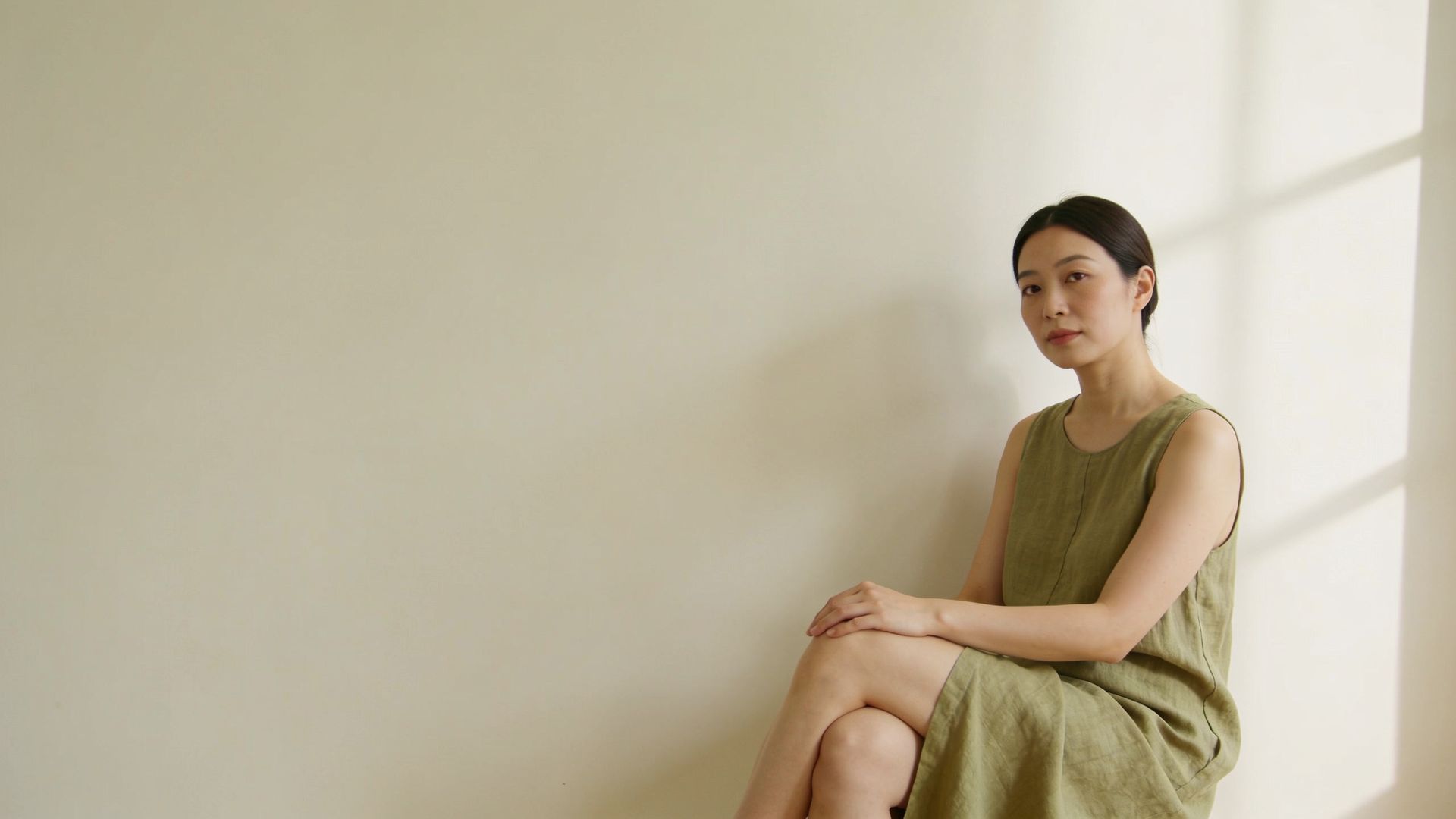 Woman with smooth skin in a linen dress, representing how long laser hair removal lasts at IN Eternity Clinic