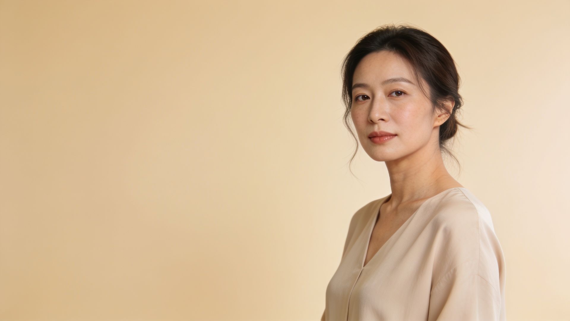 Woman with an even natural complexion in a calm clinic setting, illustrating melasma and redness care