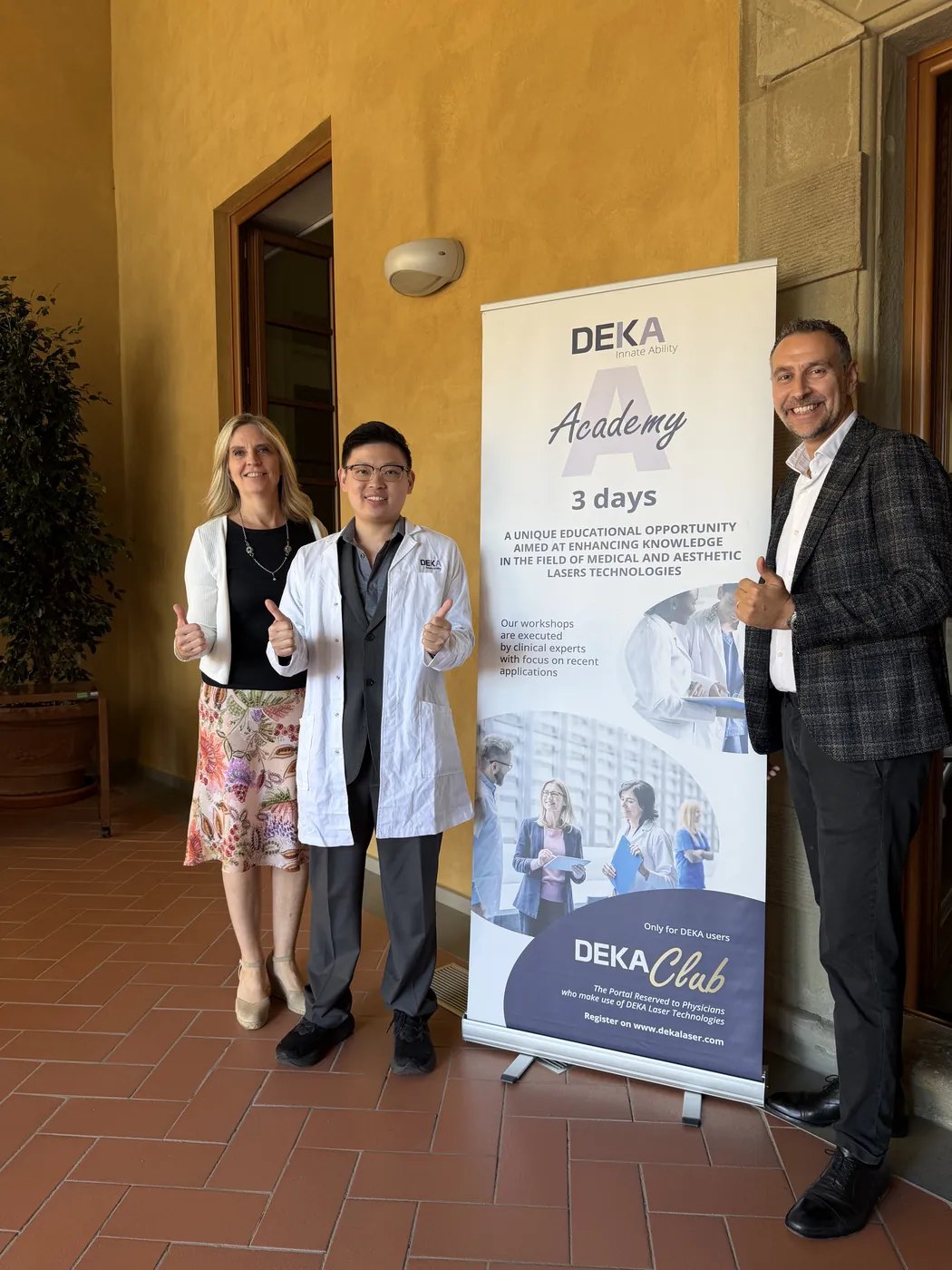 Dr Sin Yong, Medical Director of IN Eternity Clinic, with members of the DEKA team beside the DEKA Academy three-day banner in Florence