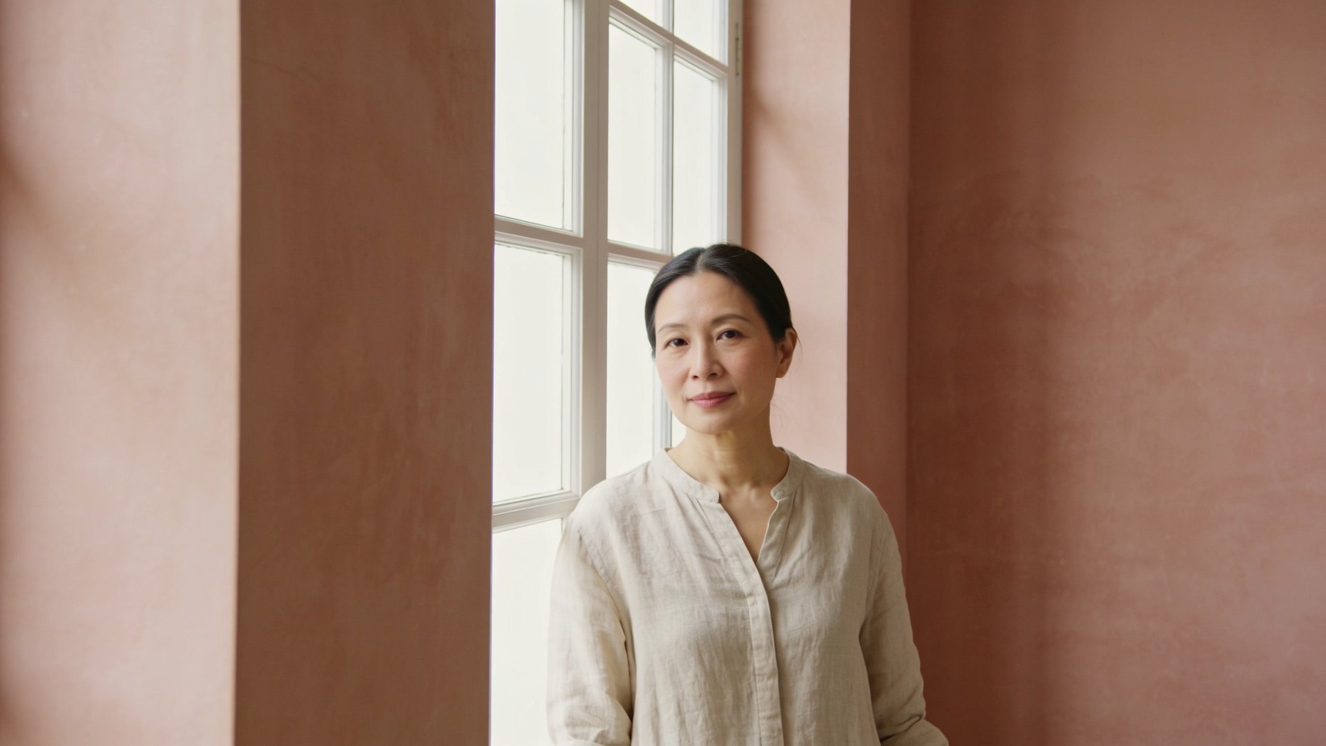Chinese Singaporean woman in her forties with calm, even skin standing by a bright window, representing Demodex mite and rosacea care at IN Eternity Clinic, Singapore